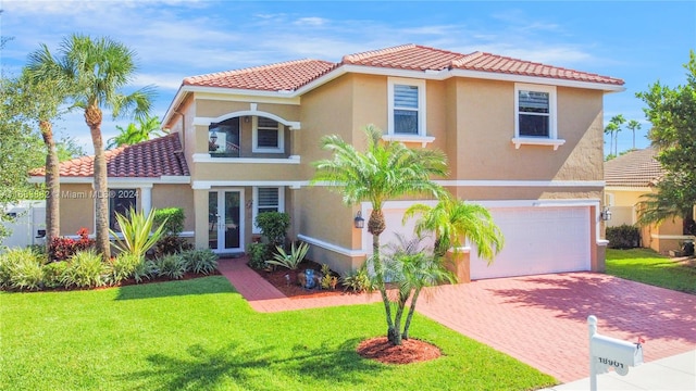 mediterranean / spanish house featuring a garage and a front lawn