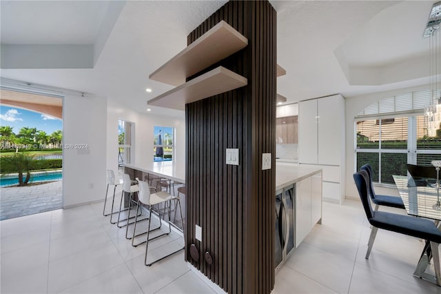 kitchen featuring a wealth of natural light, white cabinetry, and light tile patterned floors