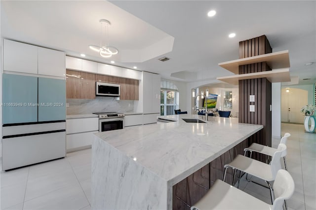 kitchen featuring white cabinets, stainless steel electric range oven, built in fridge, and decorative light fixtures