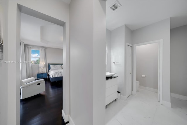 bathroom with wood-type flooring, vanity, and toilet