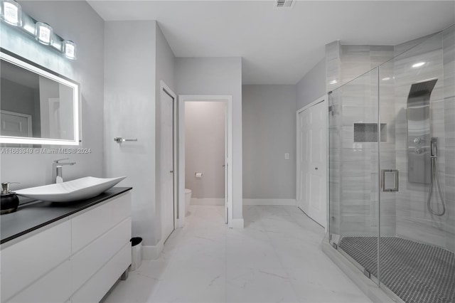 bathroom featuring vanity, toilet, and an enclosed shower