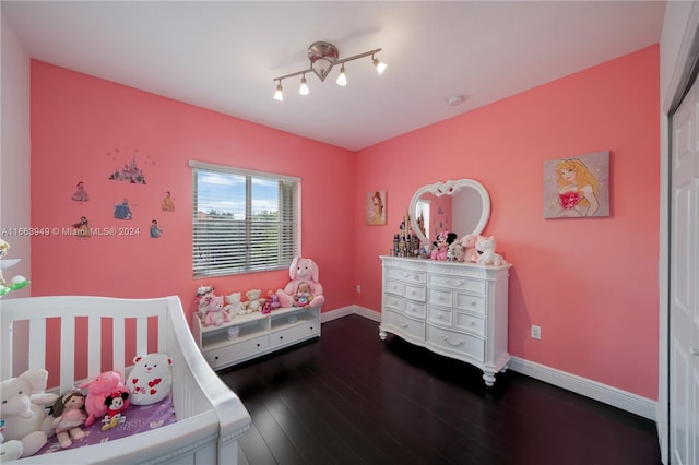 bedroom with hardwood / wood-style floors and a nursery area