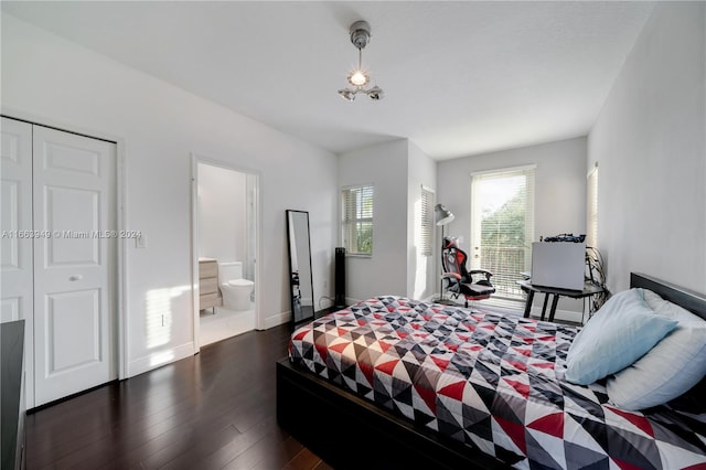 bedroom with ensuite bath, a closet, and dark hardwood / wood-style floors