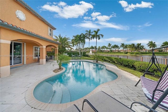 view of pool featuring a water view and a patio