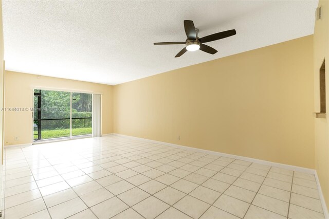 tiled spare room with ceiling fan and a textured ceiling