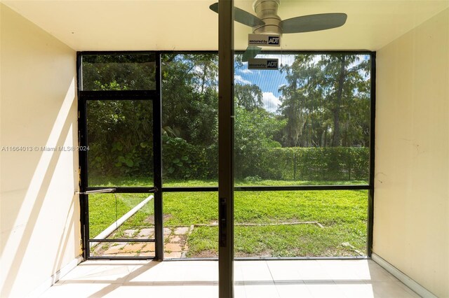 doorway to outside with ceiling fan and expansive windows