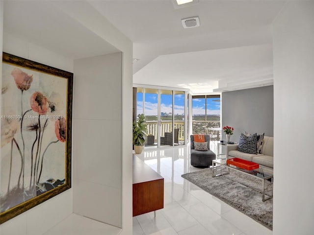 living room with a wall of windows and light tile patterned floors