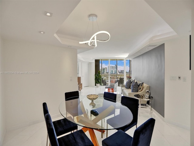 dining room with a wall of windows and a raised ceiling