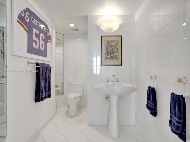 bathroom with tile walls and toilet