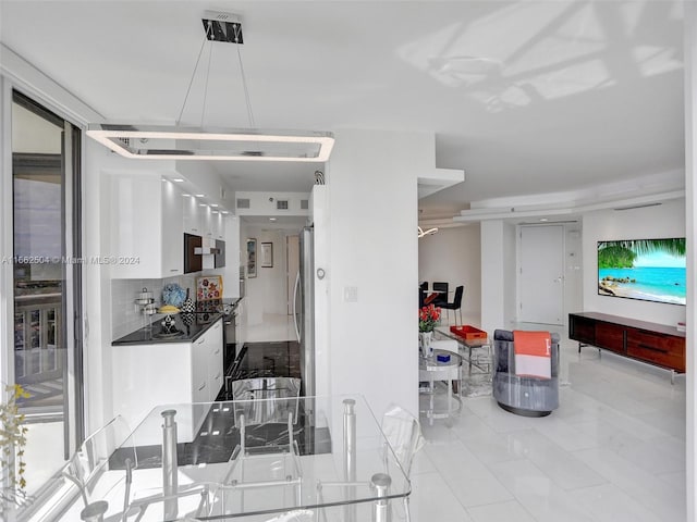 interior space with white cabinets, appliances with stainless steel finishes, light tile patterned floors, and decorative backsplash