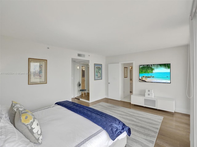 bedroom featuring wood-type flooring and ensuite bathroom