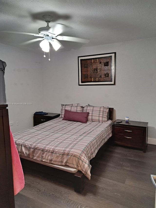 bedroom featuring ceiling fan, hardwood / wood-style flooring, and a textured ceiling