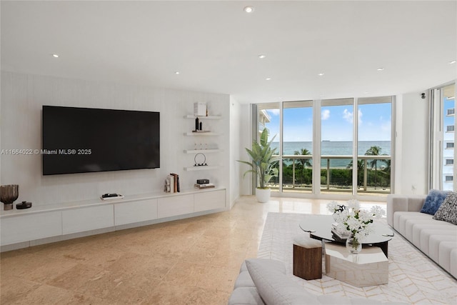 living room with a wall of windows, recessed lighting, and a water view