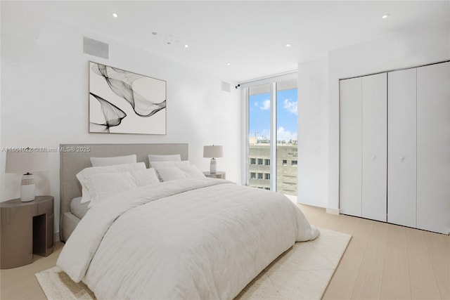 bedroom with light wood-style flooring, recessed lighting, visible vents, access to exterior, and floor to ceiling windows