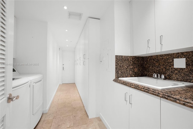 washroom featuring recessed lighting, a sink, visible vents, cabinet space, and washer and clothes dryer