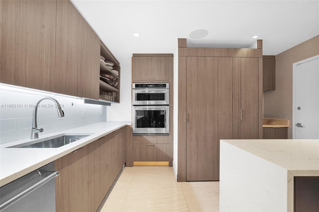 kitchen with sink, stainless steel appliances, light tile patterned floors, and tasteful backsplash