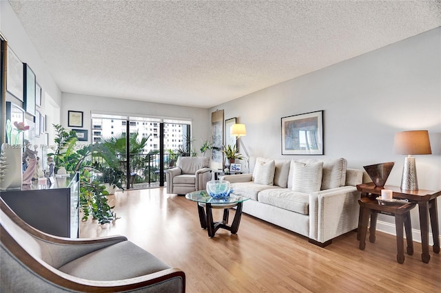 living room featuring light wood-type flooring and a textured ceiling