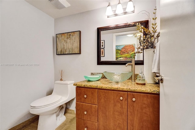 bathroom with vanity, toilet, and tile patterned floors