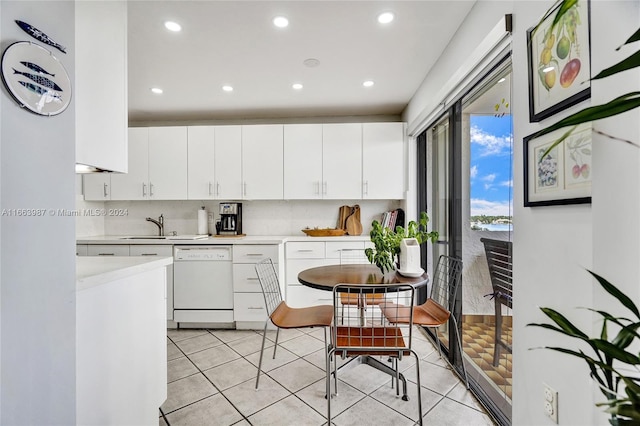 kitchen featuring light tile patterned floors, white cabinets, dishwasher, and sink