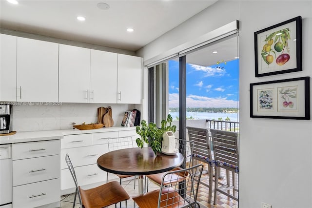 kitchen featuring white cabinets, a water view, and a healthy amount of sunlight