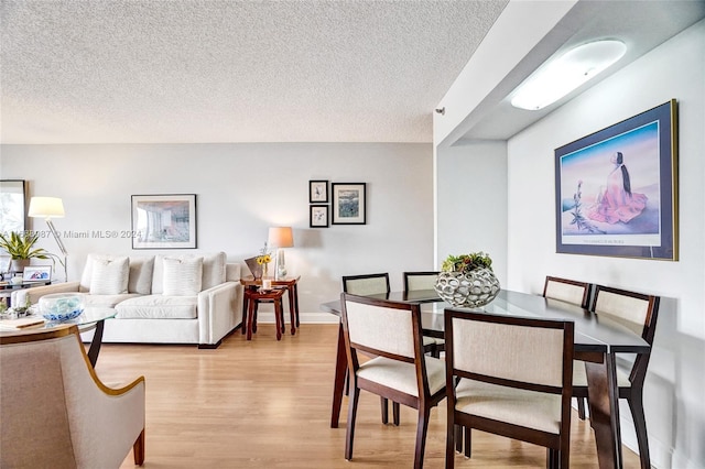 dining area featuring light hardwood / wood-style floors and a textured ceiling