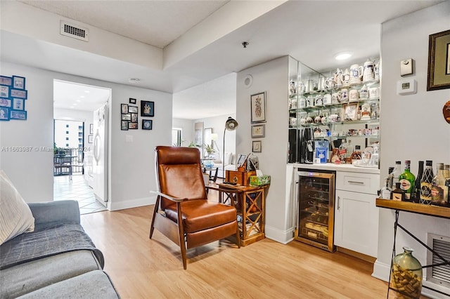 bar featuring light wood-type flooring, white refrigerator, wine cooler, and white cabinets