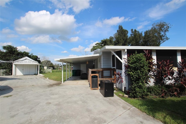 view of front of property featuring an outdoor structure, a garage, a front lawn, and a carport