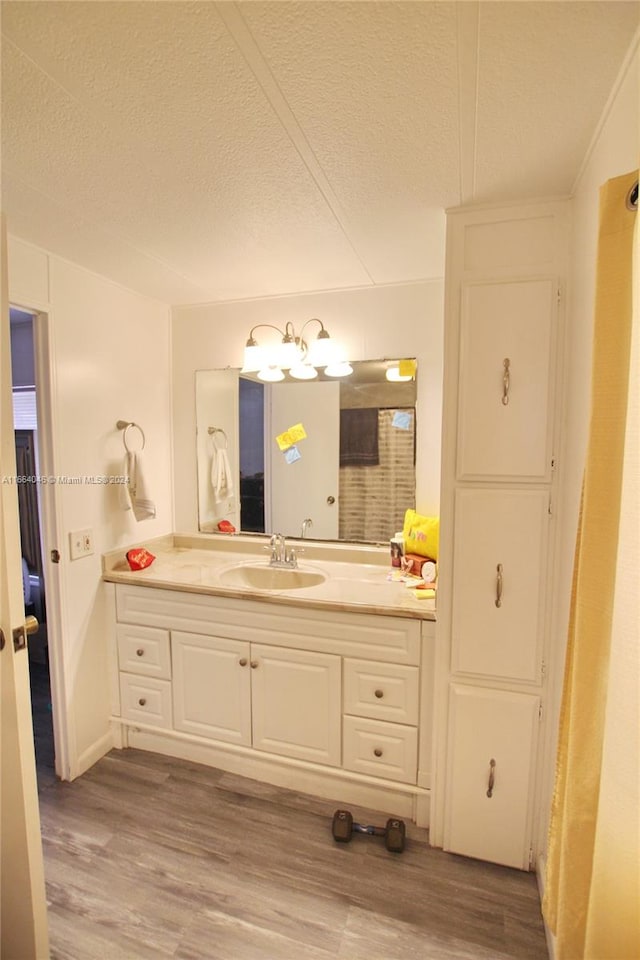 bathroom with a textured ceiling, hardwood / wood-style flooring, and vanity