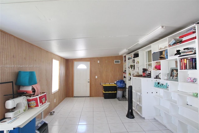 misc room featuring wood walls and light tile patterned floors