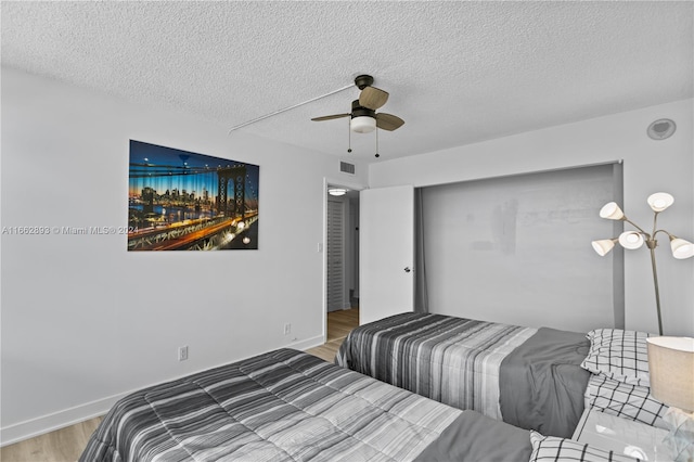 bedroom featuring ceiling fan, a textured ceiling, and hardwood / wood-style floors