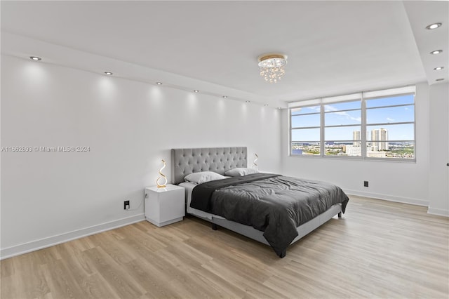 bedroom featuring light hardwood / wood-style flooring and a chandelier