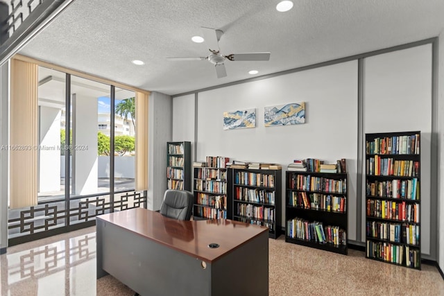 carpeted office space featuring a textured ceiling, ceiling fan, and expansive windows