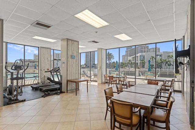 tiled dining area with a wall of windows and a paneled ceiling