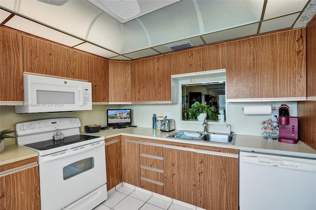 kitchen with sink, light tile patterned floors, and white appliances