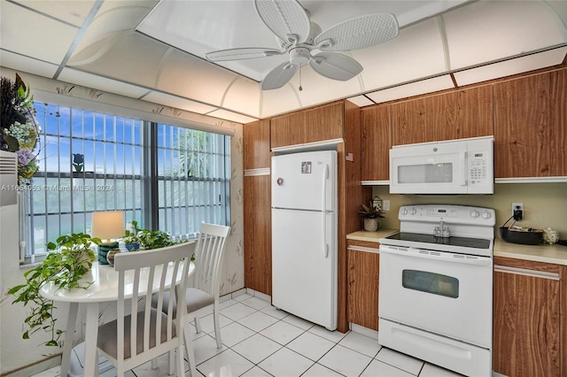 kitchen featuring ceiling fan, wood walls, light tile patterned flooring, a water view, and white appliances