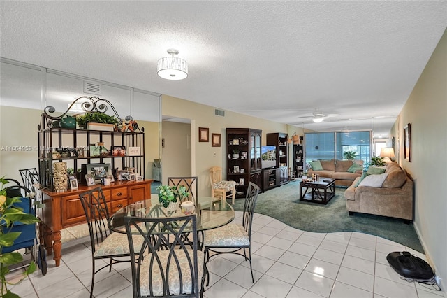 tiled dining area featuring a textured ceiling and ceiling fan