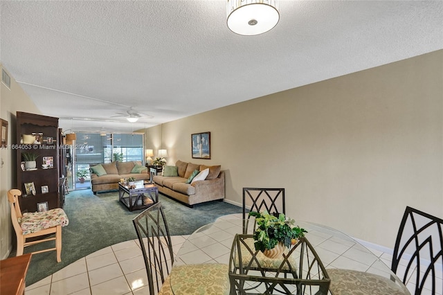 tiled dining room featuring ceiling fan and a textured ceiling