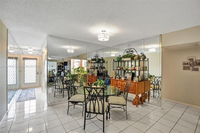 dining space with a textured ceiling and light tile patterned floors