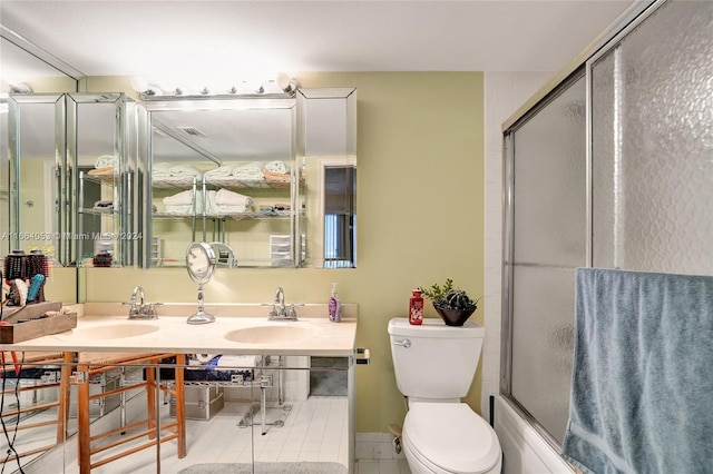 full bathroom featuring toilet, vanity, tile patterned floors, and shower / bath combination with glass door