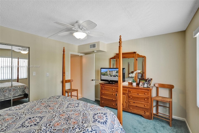 carpeted bedroom featuring ceiling fan and a textured ceiling