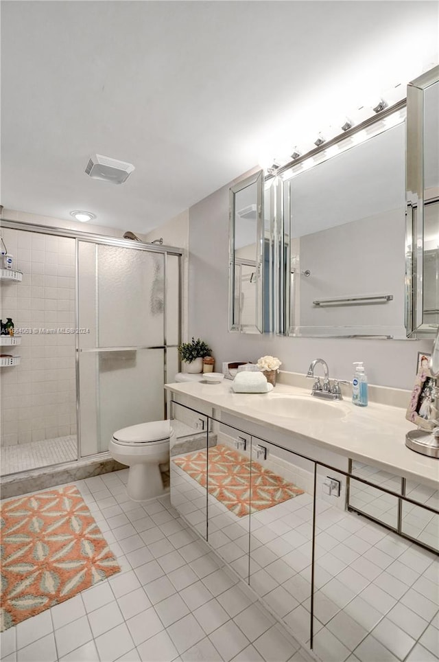 bathroom with toilet, walk in shower, vanity, and tile patterned flooring