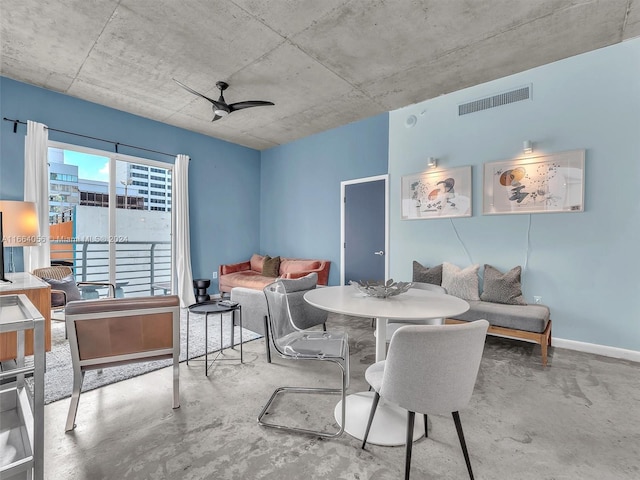 dining room with ceiling fan and concrete flooring