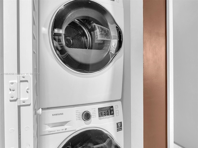 clothes washing area with stacked washer and clothes dryer