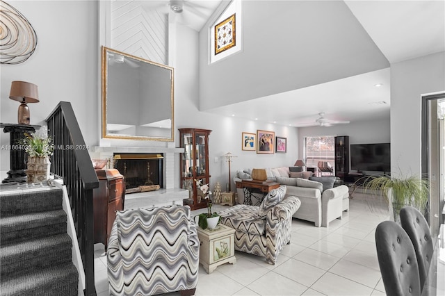 living room with ceiling fan, light tile patterned flooring, and a fireplace