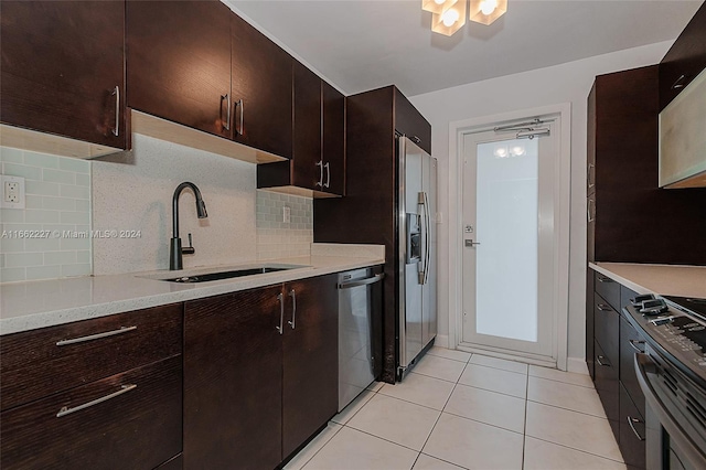 kitchen with sink, decorative backsplash, stainless steel appliances, dark brown cabinetry, and light tile patterned floors