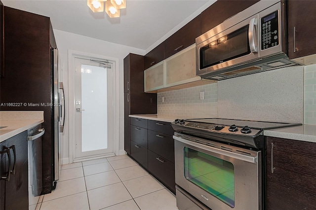 kitchen with dark brown cabinetry, light tile patterned flooring, appliances with stainless steel finishes, and decorative backsplash