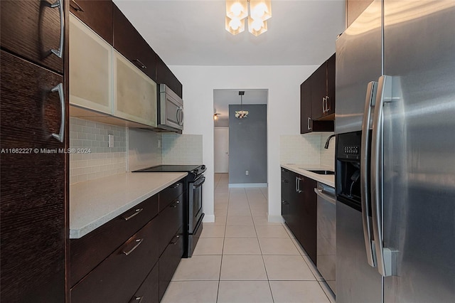 kitchen featuring pendant lighting, light tile patterned floors, sink, appliances with stainless steel finishes, and decorative backsplash