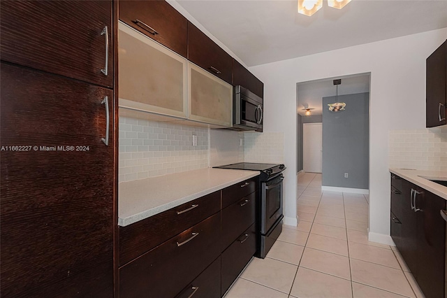 kitchen featuring dark brown cabinetry, light tile patterned floors, tasteful backsplash, black electric range, and decorative light fixtures