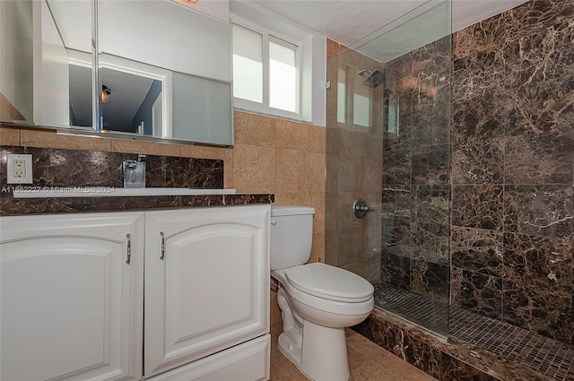 bathroom featuring vanity, tile walls, toilet, and tiled shower