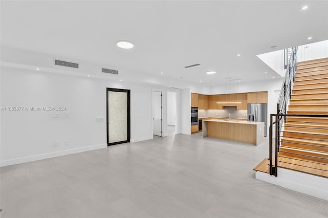 unfurnished living room featuring sink